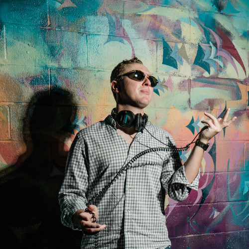 Malgum wearing headphones in front of a painted wall